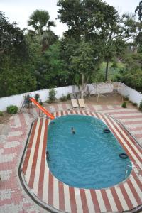 a swimming pool with two people in the water at Hotel Maurya Vihar Bodhgaya in Bodh Gaya
