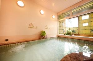 松山市にあるホテル泰平の大きな窓付きの客室内のスイミングプールを利用できます。