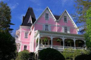 uma casa cor-de-rosa com um telhado preto em Cedar Crest Inn em Asheville