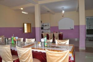 a banquet hall with a table and chairs at Hotel Maurya Vihar Bodhgaya in Bodh Gaya