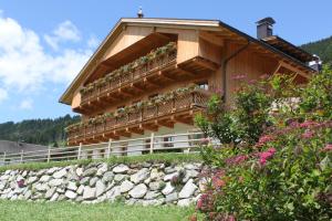 a building with a balcony with flowers on it at Huberhof in San Candido