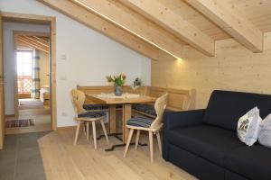 ein Wohnzimmer mit einem Sofa, einem Tisch und Stühlen in der Unterkunft Huberhof in Innichen