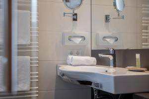 a bathroom with a white sink and towels at Hotel Garni Pirchhütt in Obergurgl