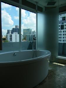 a large bath tub in a room with a window at Baannueng at Aree 5 Hotel in Bangkok