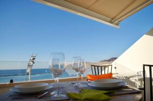 La Grand Suite Las Canteras في لاس بالماس دي غران كاناريا: طاولة مع كؤوس للنبيذ وإطلالة على المحيط