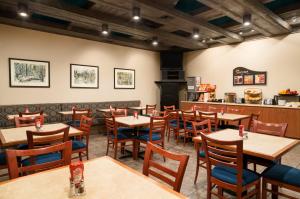 uma sala de jantar com mesas e cadeiras de madeira em The Senator Hotel & Conference Center Timmins em Timmins