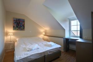 ein Schlafzimmer mit einem weißen Bett und einem Fenster in der Unterkunft Aparthotel Hine Adon Fribourg in Freiburg im Üechtland