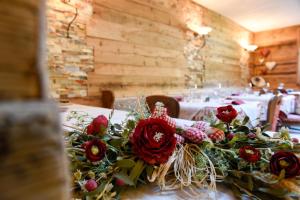 uma mesa com um ramo de rosas vermelhas em Agriturismo Baita De L'ALL em Valdidentro