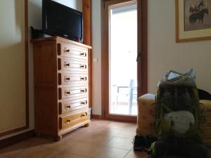 a living room with a dresser with a television and a stroller at Hostal La Catalana in Sant Llorenc de Morunys