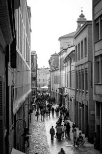 un grupo de personas caminando por una calle de la ciudad en Maison degli Artisti, en Rávena