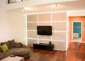 salon z kanapą i telewizorem z płaskim ekranem w obiekcie Apartament Posmyka w mieście Słupsk