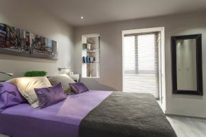 a bedroom with a purple bed with a large window at Elegant Eixample Apartment nicely decorated in Barcelona