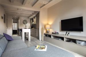 a living room with a couch and a flat screen tv at Elegant Eixample Apartment nicely decorated in Barcelona