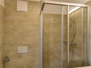 La salle de bains est pourvue d'une douche avec une porte en verre. dans l'établissement Penthouse am Sonnenhang, à Neukirchen am Großvenediger