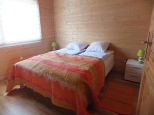 a bedroom with a bed in a wooden room at Les Chalets Fleurs de France - KOTA in Saint-Dalmas