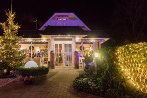 a house decorated with christmas lights and a christmas tree at Apart Hotel Haveltreff in Caputh