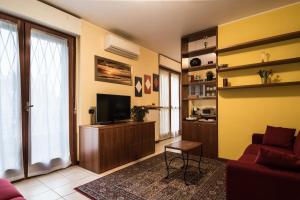 sala de estar con sofá y TV en Cozy Penthouse, en San Donato Milanese