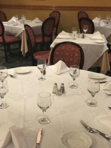 a table with white table cloth and wine glasses on it at Meadowlands Plaza Hotel in Secaucus
