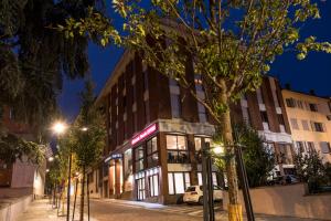 a building on the side of a street at night at Hotel Astoria in Fidenza