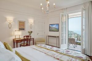 a bedroom with a bed and a desk and a balcony at Splendido, A Belmond Hotel, Portofino in Portofino