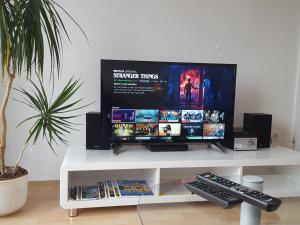 einen Flachbild-TV auf einem weißen Tisch in der Unterkunft Apartment Weitblick Hannover in Hannover