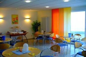 a dining room with tables and chairs and a room with a unintention at Hotel Ernst Ludwig in Darmstadt