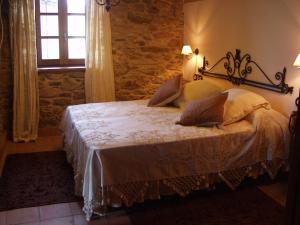 1 dormitorio con 1 cama en una habitación con ventana en Casa Almoina, en Viveiro