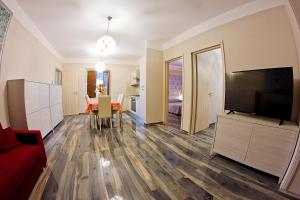 a living room with a television and a dining room at Il Merlo Verde in Monteverdi Marittimo