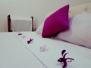 un letto con cuscini e decorazioni viola di South Heaven Villa a Hikkaduwa