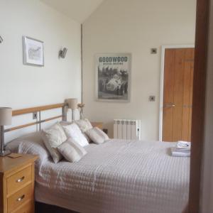 チチェスターにあるOak Lodgeのベッドルーム1室(白いシーツ付きのベッド1台、ドア付)