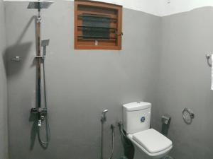 un bagno con wc e doccia con finestra di South Heaven Villa a Hikkaduwa Altre 34 foto