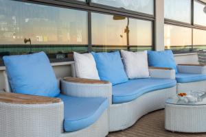 eine Veranda mit blauen und weißen Stühlen und Fenstern in der Unterkunft Hotel Igea Spiaggia in Bellaria-Igea Marina