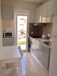 a kitchen with white cabinets and a white table at LAS PERLAS - 1º Linea in Denia