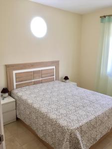 a bedroom with a bed with a white comforter at LAS PERLAS - 1º Linea in Denia