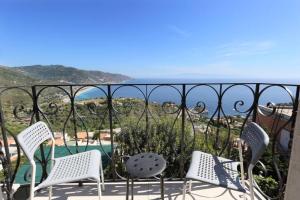 a balcony with chairs and a view of the ocean at Villa Astoria in Taormina