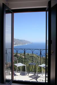 a balcony with chairs and a view of the ocean at Villa Astoria in Taormina