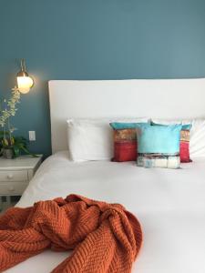 a brown blanket laying on a white bed with pillows at Inn at Playa del Rey in Los Angeles