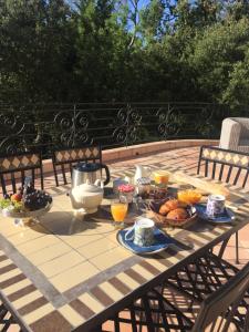 a picnic table with a breakfast of fruit and juice at La Garriniere in Saint-Raphaël