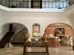 eine Lobby mit einer Treppe und einem Tisch mit Vasen darauf in der Unterkunft Hôtel Chantaco Golf & Wellness in Saint-Jean-de-Luz