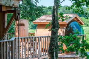 einen hölzernen Pavillon auf einer Terrasse mit einem Baum in der Unterkunft Bois Des Nauzes in Seyches