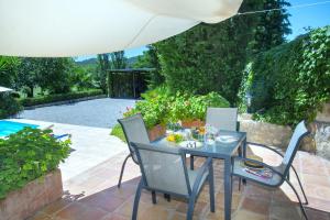 ポリェンサにあるOwl Booking Villa Bennasar - Rustic Stayのパティオ(テーブル、椅子付)、プールが備わります。