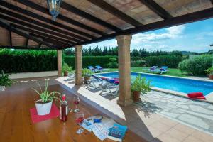 a patio with a pool and a table with wine glasses at Owl Booking Villa Maria - Family and Friends in El Port
