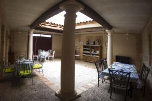 un comedor con mesas y sillas y un arco en Casa Rural La Biblioteca, en Almagro