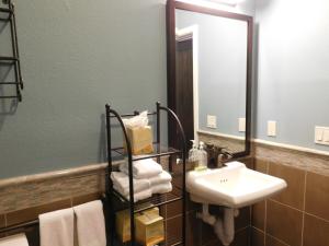 a bathroom with a sink and a mirror and towels at Wave Street Inn in Monterey
