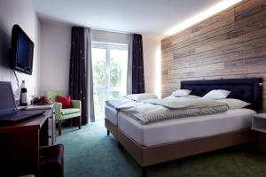 1 dormitorio con 1 cama grande y pared de madera en Hotel Restaurant Anna, en Schnelldorf