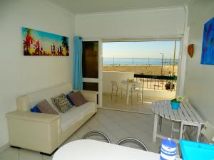 a living room with a couch and a view of the beach at Apartment Vasco da Gama in Costa da Caparica