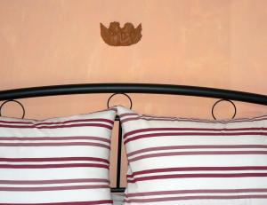 a bed with two pillows and a butterfly on the wall at Alpha Omega (AΩ) Vintage Suite in Thessaloniki