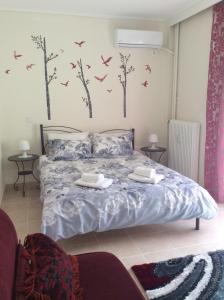 a bedroom with a bed with birds on the wall at Sunny apartment in Athens