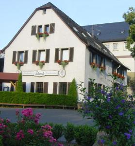 ein weißes Gebäude mit Blumen davor in der Unterkunft Landgasthof Schuck in Idar-Oberstein