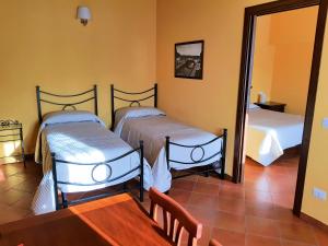 two beds in a room with a table and a mirror at Corte Certosina in Trezzano sul Naviglio